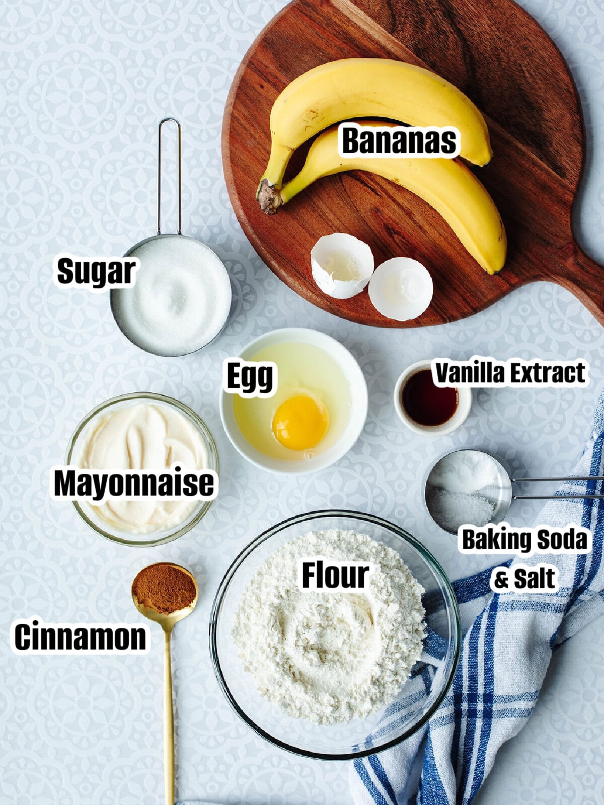 Ingredients for homemade banana bread including bananas, mayonnaise, flour, and sugar.