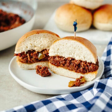 Sloppy joes served on buttery bread machine rolls on a white plate.