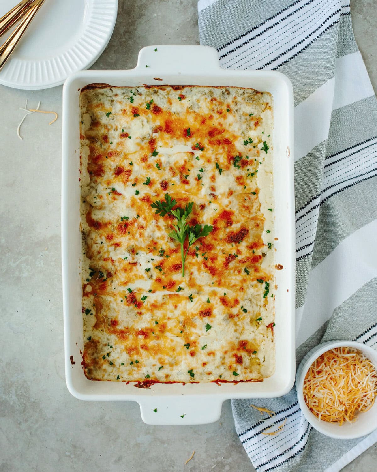 A white baking dish with sour cream chicken enchiladas ready to serve.
