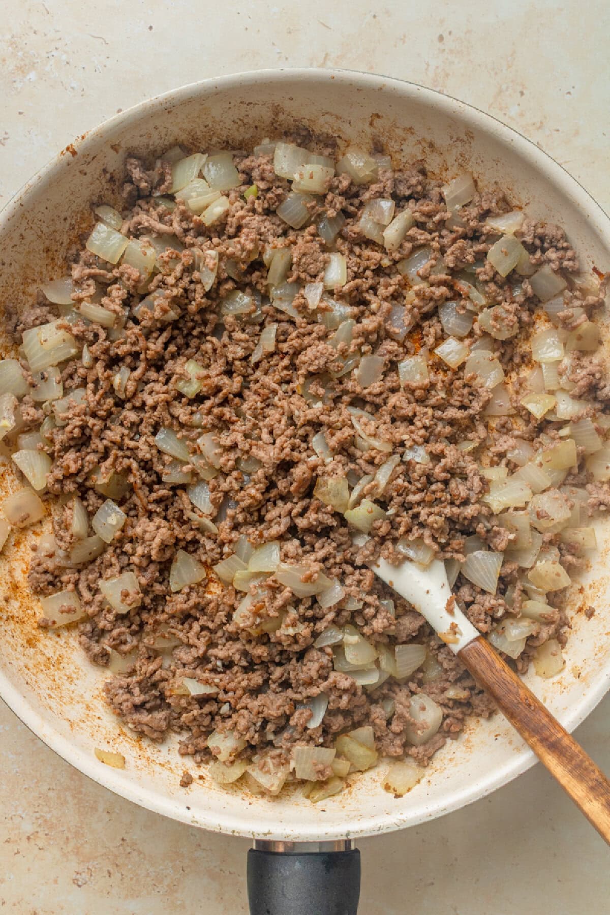 Ground beef, onion, and garlic cooked in a skillet.