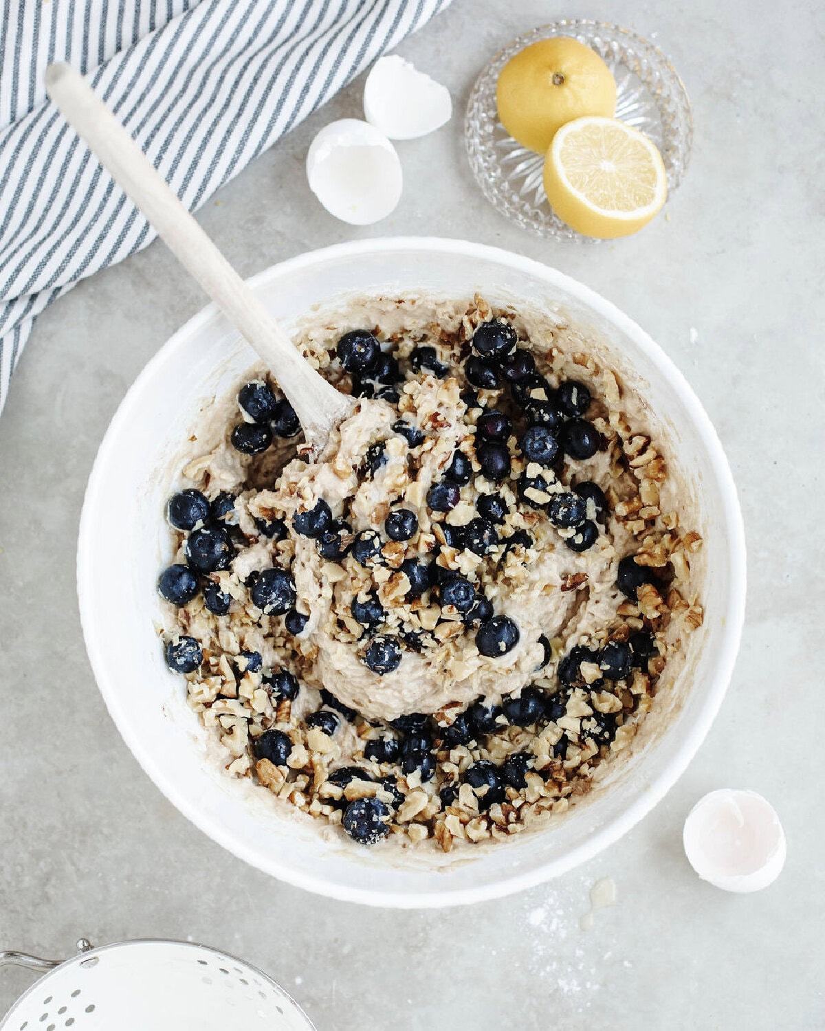 Blueberries folded into bread batter in a mixing bowl.