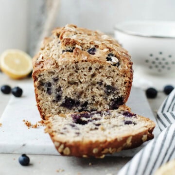 A slice of blueberry lemon oatmeal bread ready to serve.