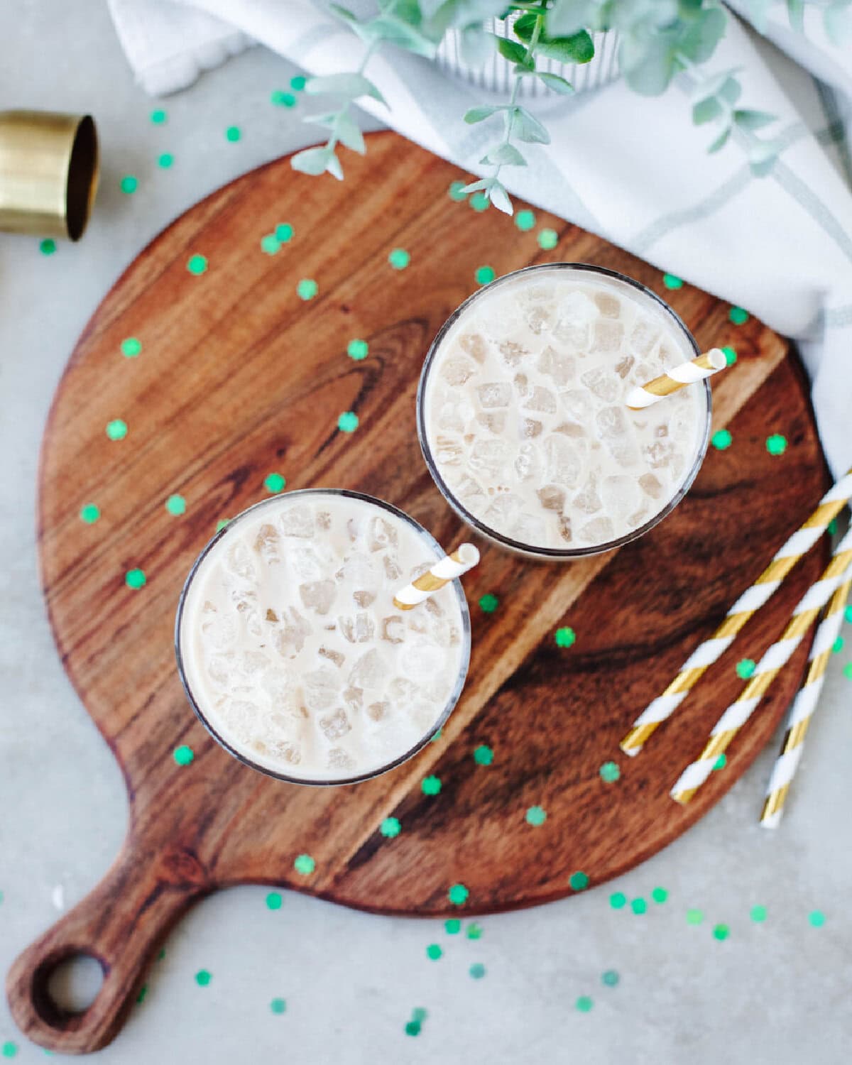 Whiskey and Kahlua over ice in a glass with paper straws.