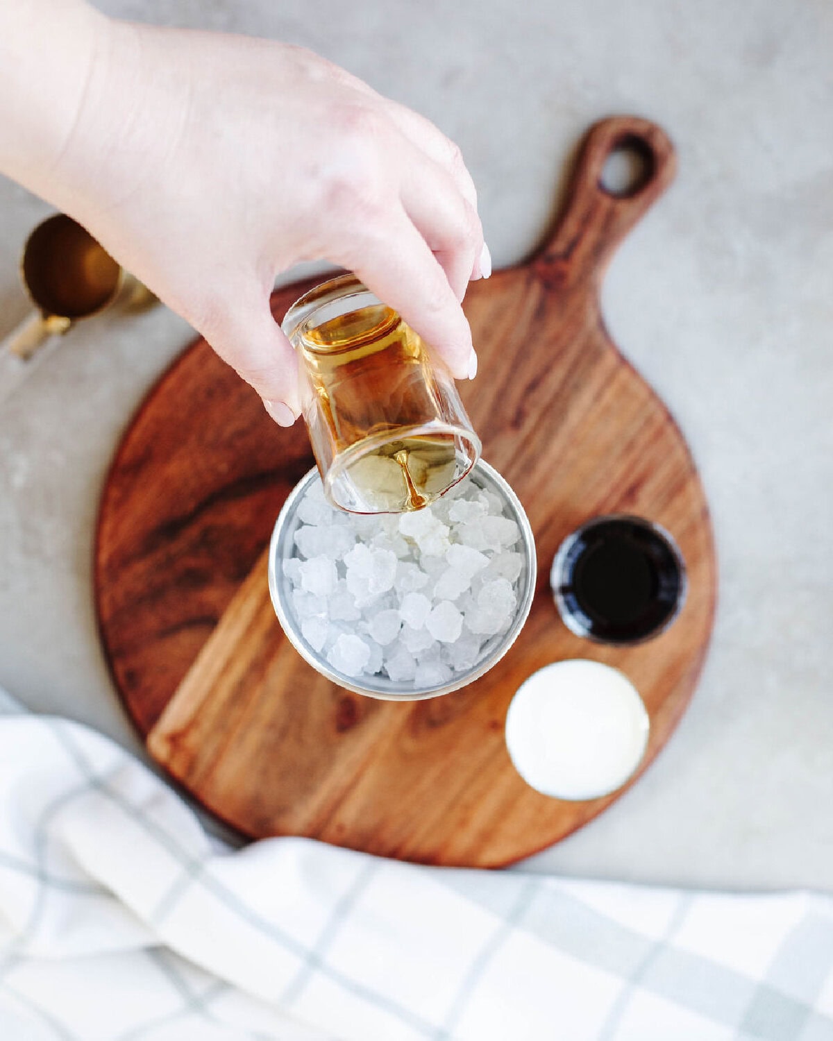 Whiskey poured over ice in a cocktail shaker.
