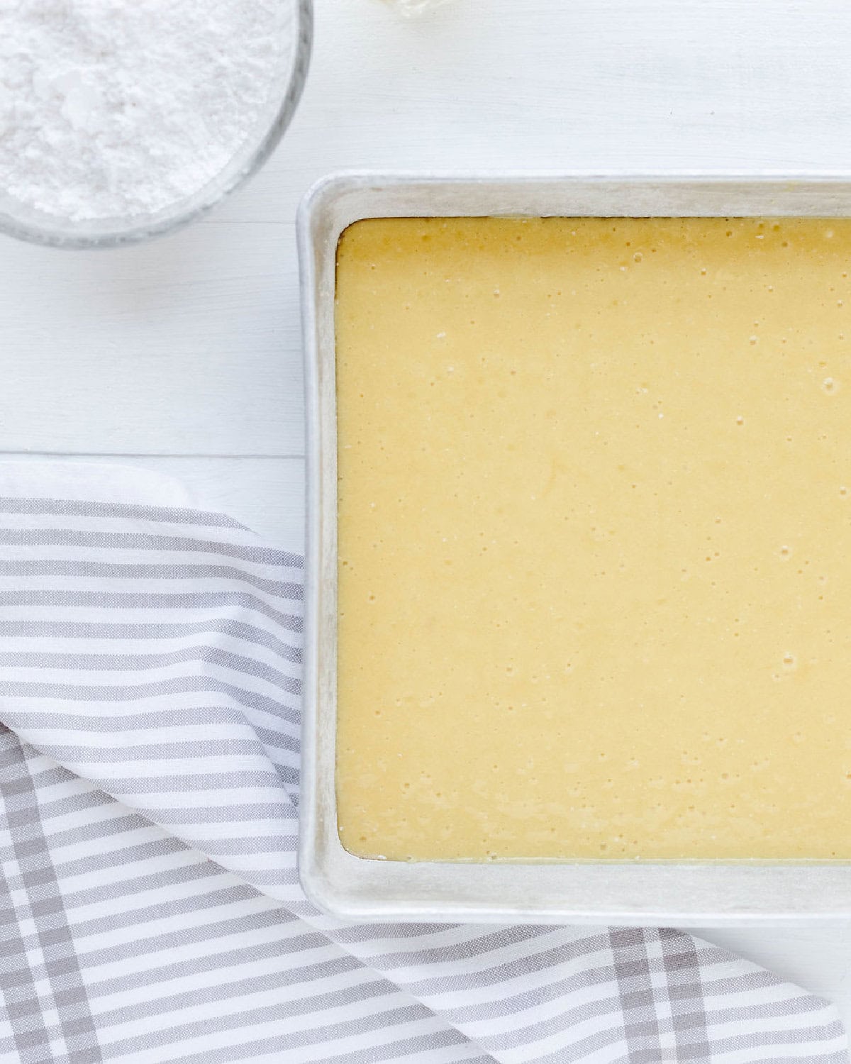 Lemon poke cake batter spread into a prepared pan.