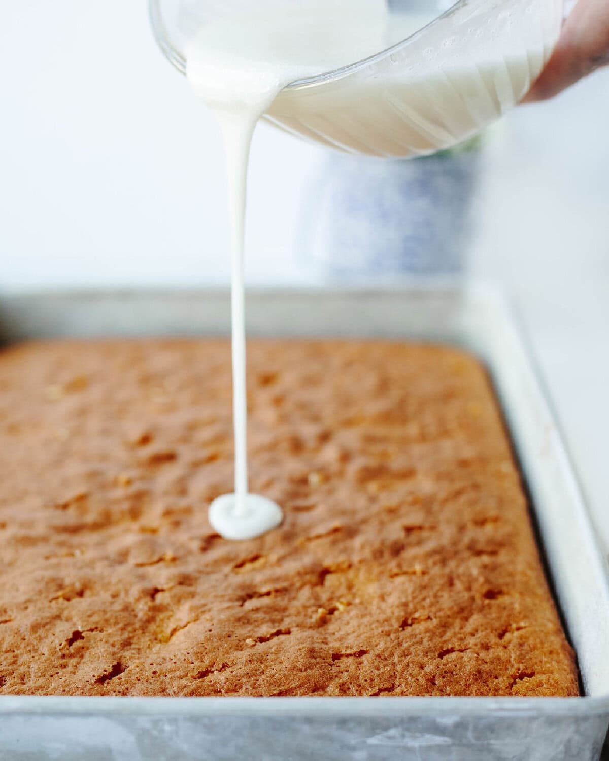 Glaze poured onto a lemon poke cake.