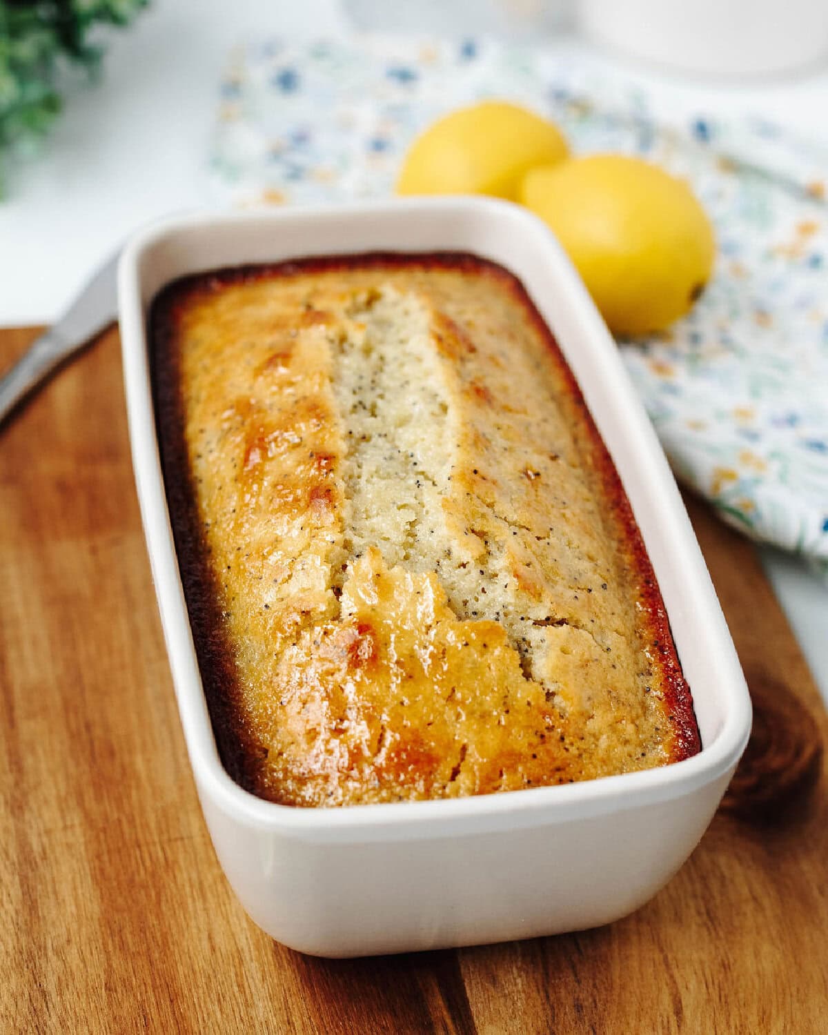 homemade lemon poppyseed bread in loaf pan with glaze.