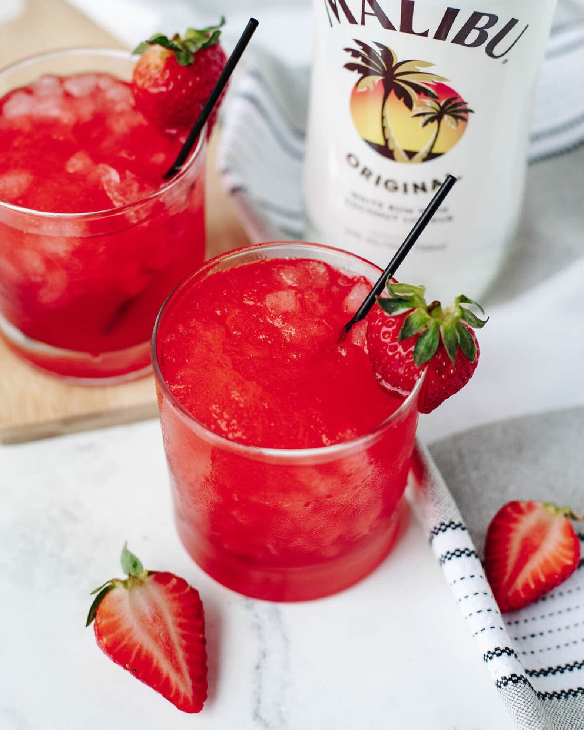 Liquid Skittles cocktail served in a glass with strawberry garnish.