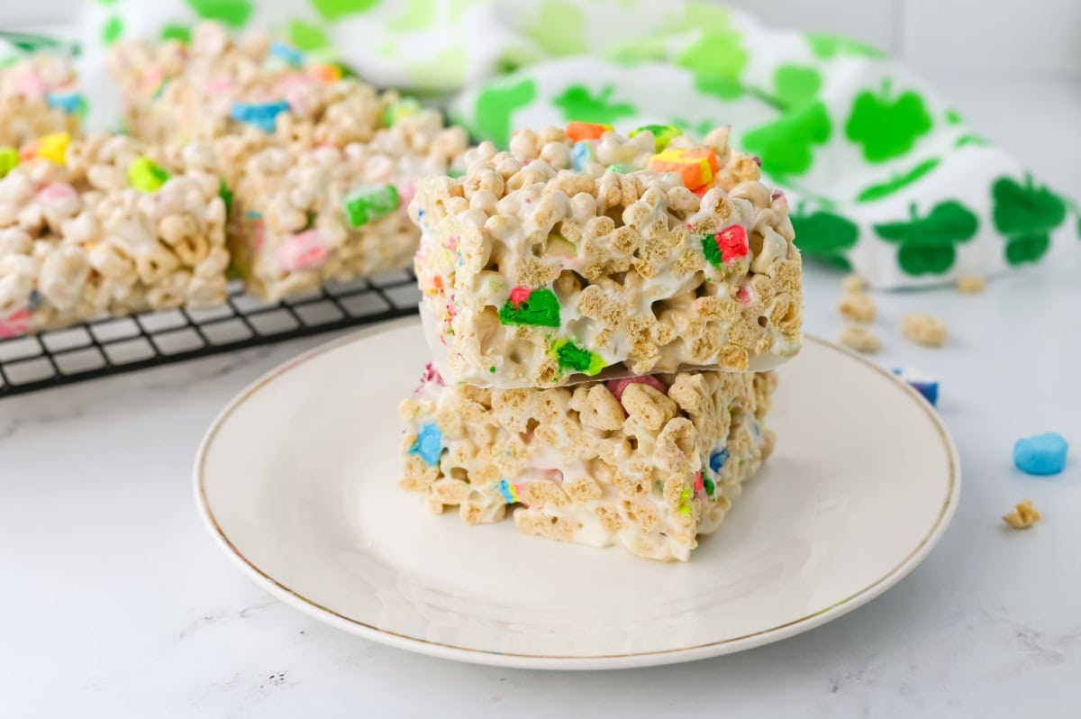 A stack of lucky charm marshmallow bars on a white plate.