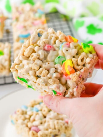 A slice of Lucky Charms cereal bars in a hand being served.