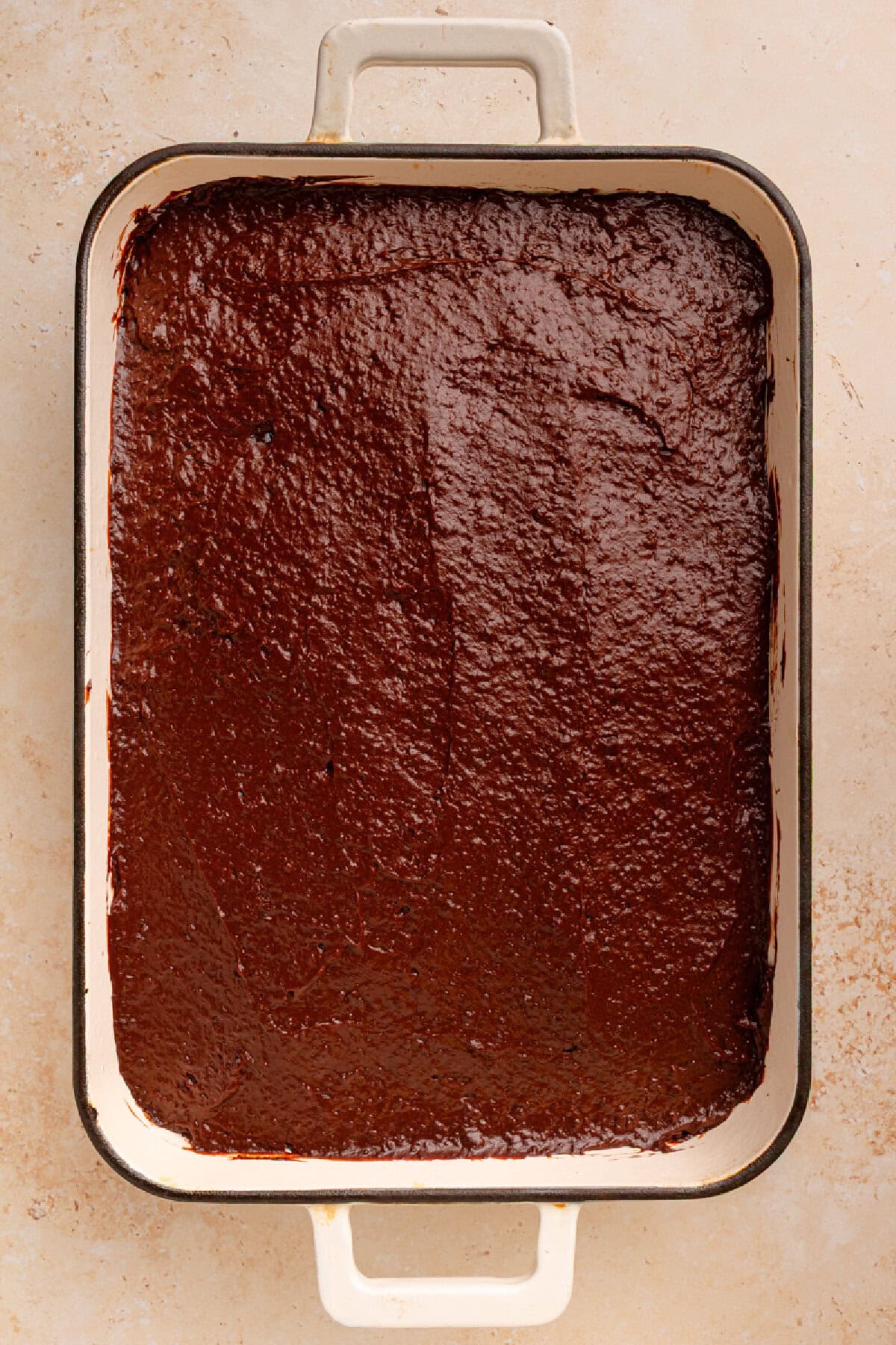 Chocolate pudding spread on top of a chocolate cake.