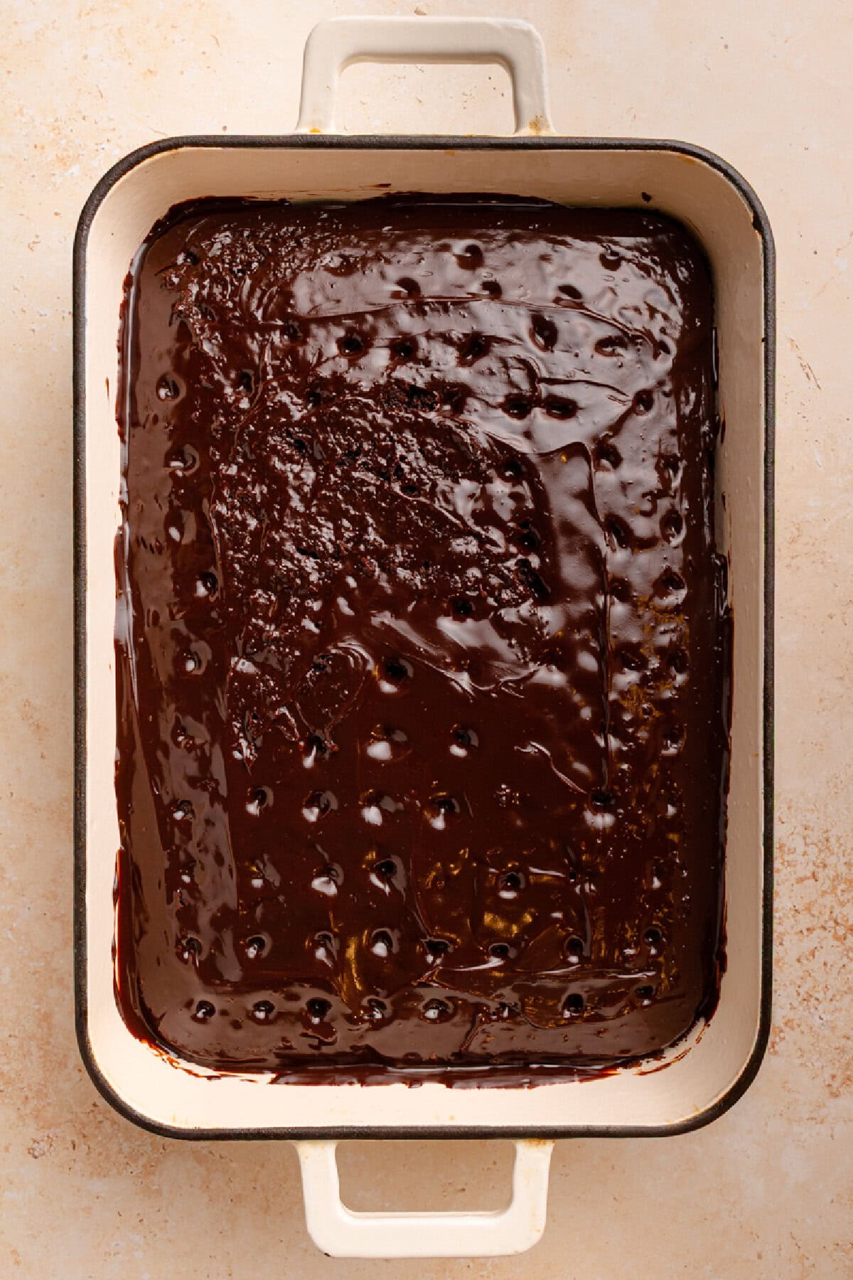 Warm and melted hot fudge on top of a chocolate cake.