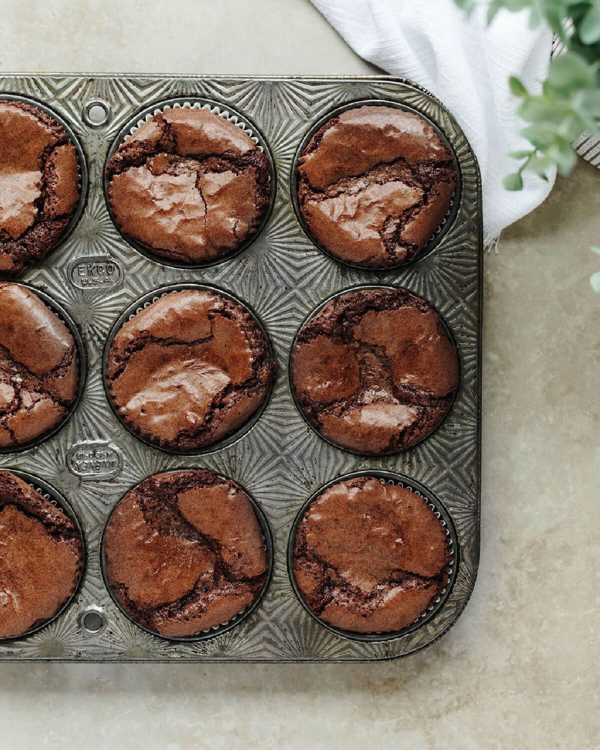 Baked brownie cookie cups in a muffin tray.