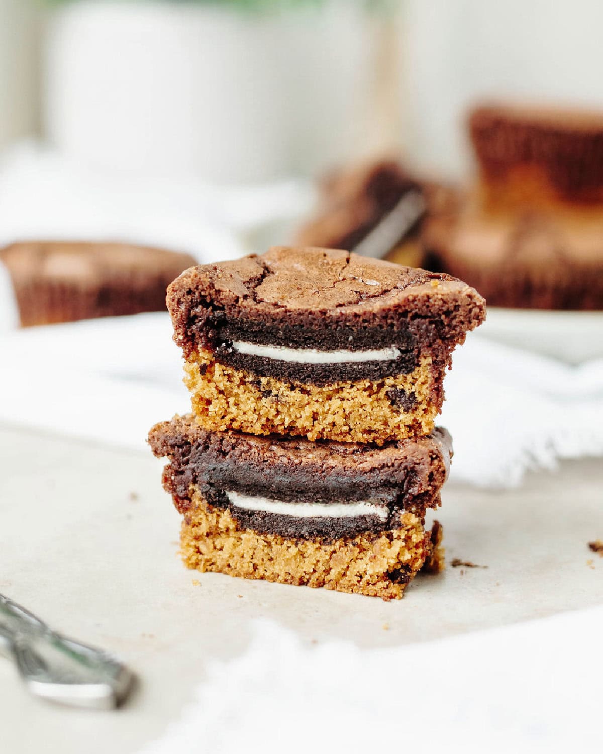 A stack of Slutty brownie cupcakes sliced in half to show the Oreo center.