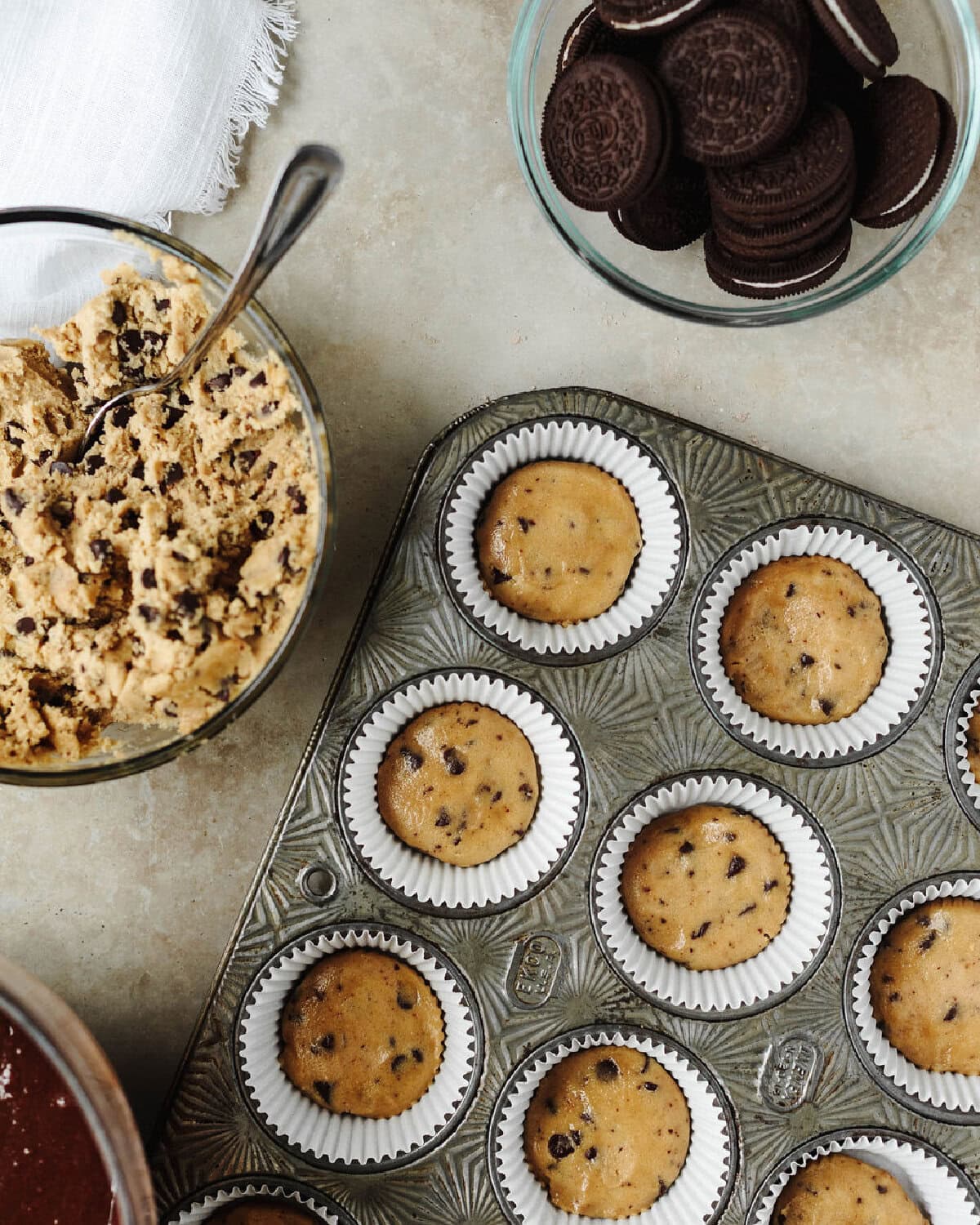 Cookie dough pressed into the bottom of lined muffin cups.