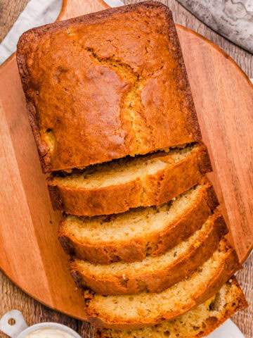 Sliced loaf of peach bread on a wood serving board ready to serve.