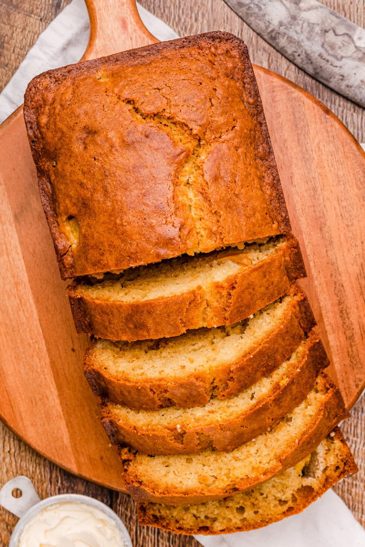 fresh peach bread loaf sliced on a wooden board.