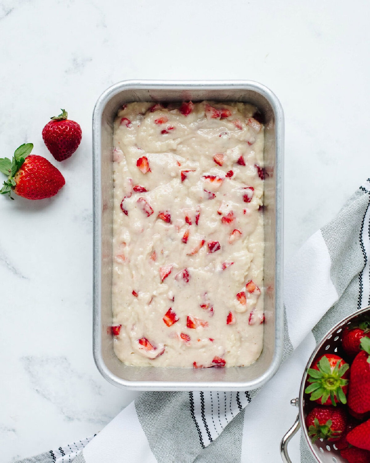 Prepared batter spread into a lined loaf pan before baking.