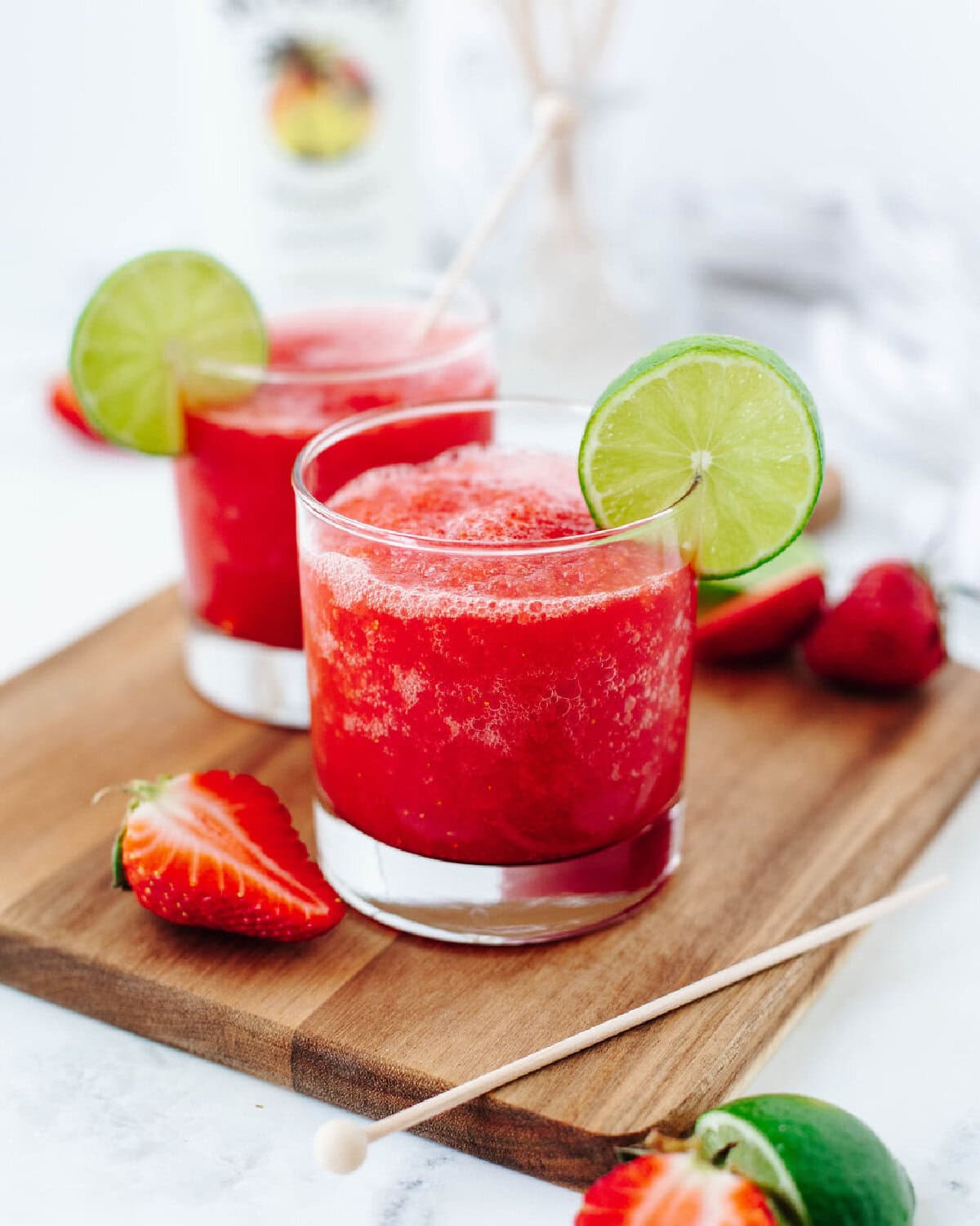 A side view of a strawberry coconut daiquiri served with a lime wedge.