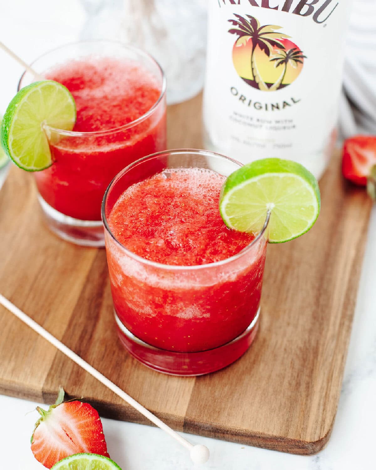 A fruity blended alcohol drink in a glass with a lime wedge.