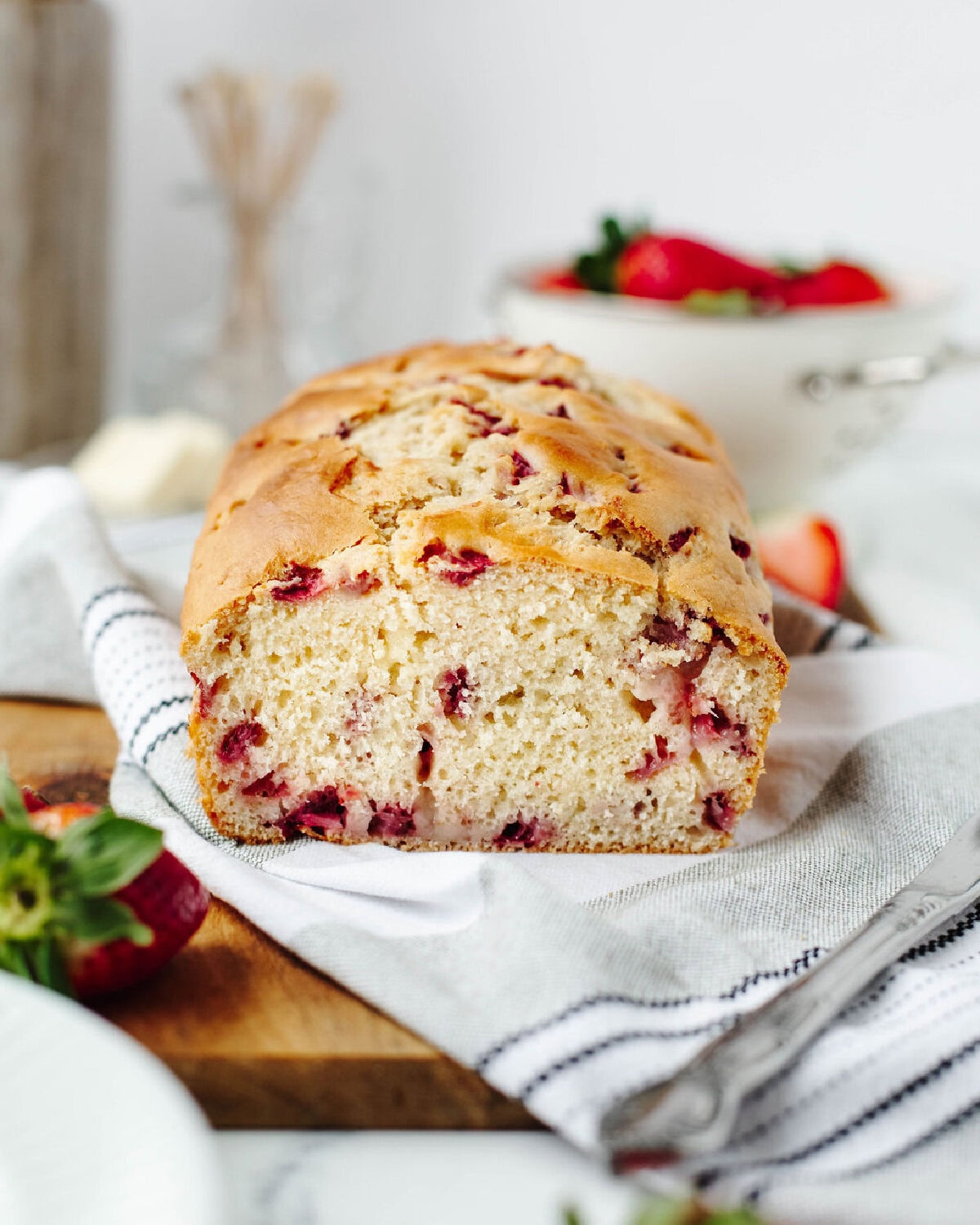 Slice showing the soft crumb and strawberries inside.