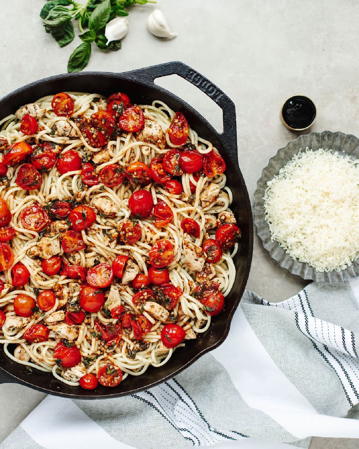 Cherry tomatoes mixture combined with cooked pasta in a skillet.