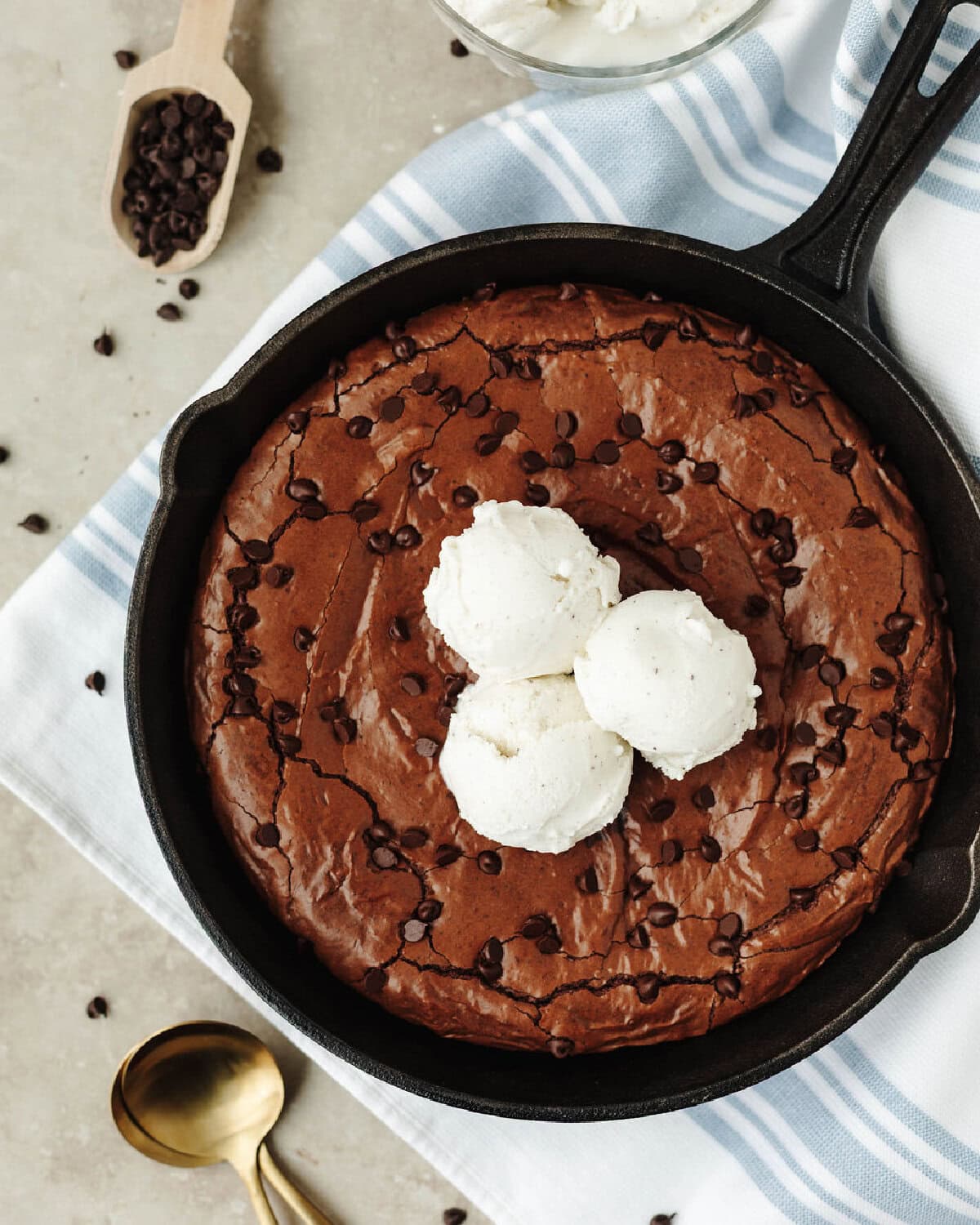 Cast iron skillet brownies baked and topped with vanilla ice-cream.