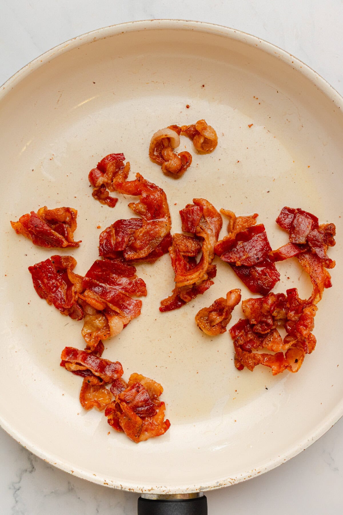 Bacon cooked in a skillet until crispy.