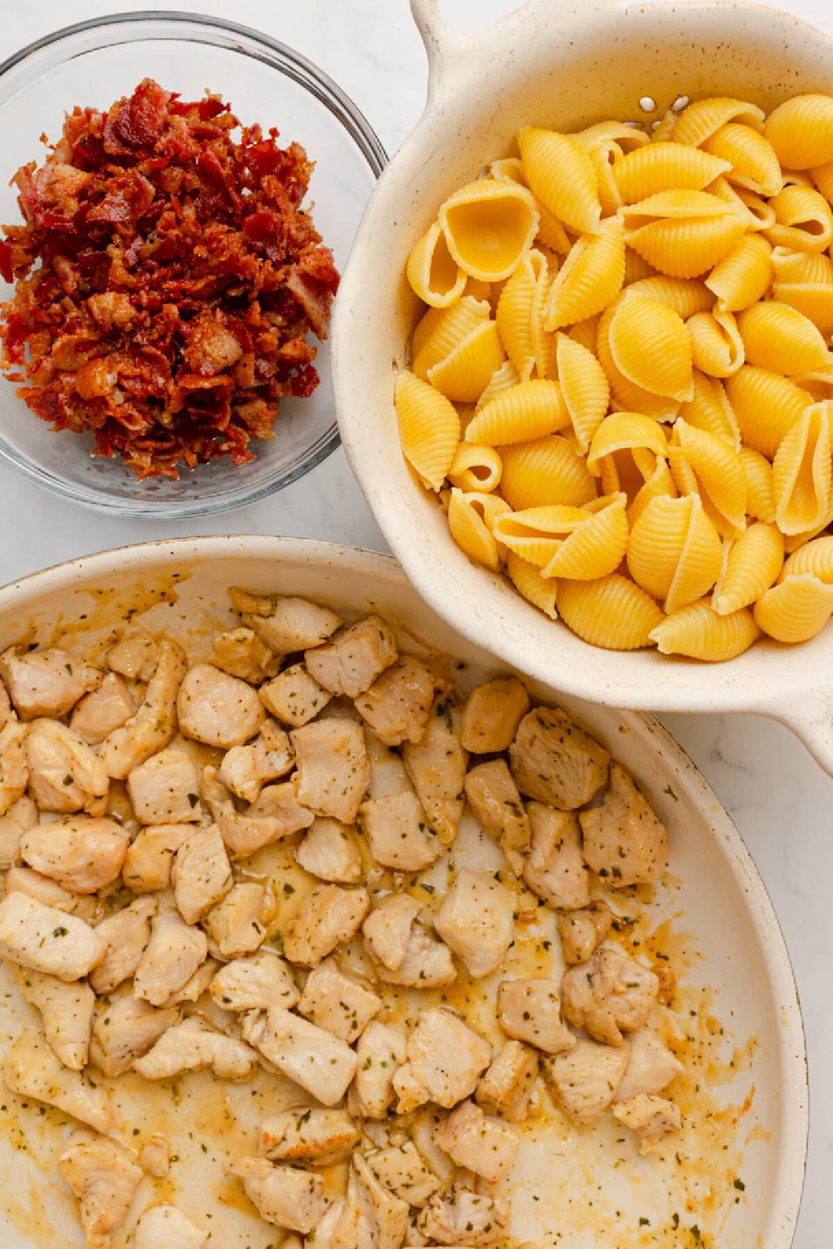 Cooked chicken, pasta, and bacon ready to assemble into a casserole.