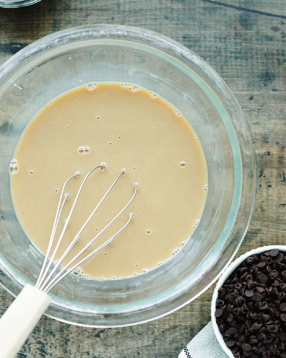 Sweetened condensed milk and Kahlua combined in a glass mixing bowl.