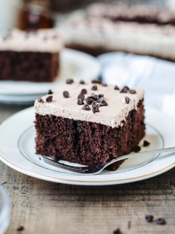 A slice of Kahlua poke cake served on a white plate with a fork.