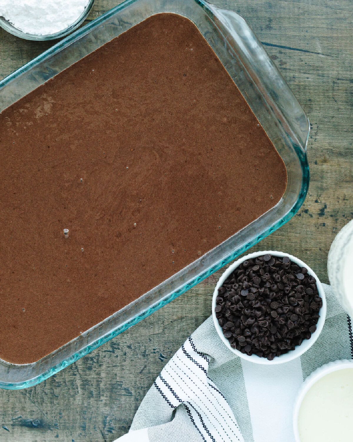 Chocolate cake batter spread evenly into a prepared baking pan.