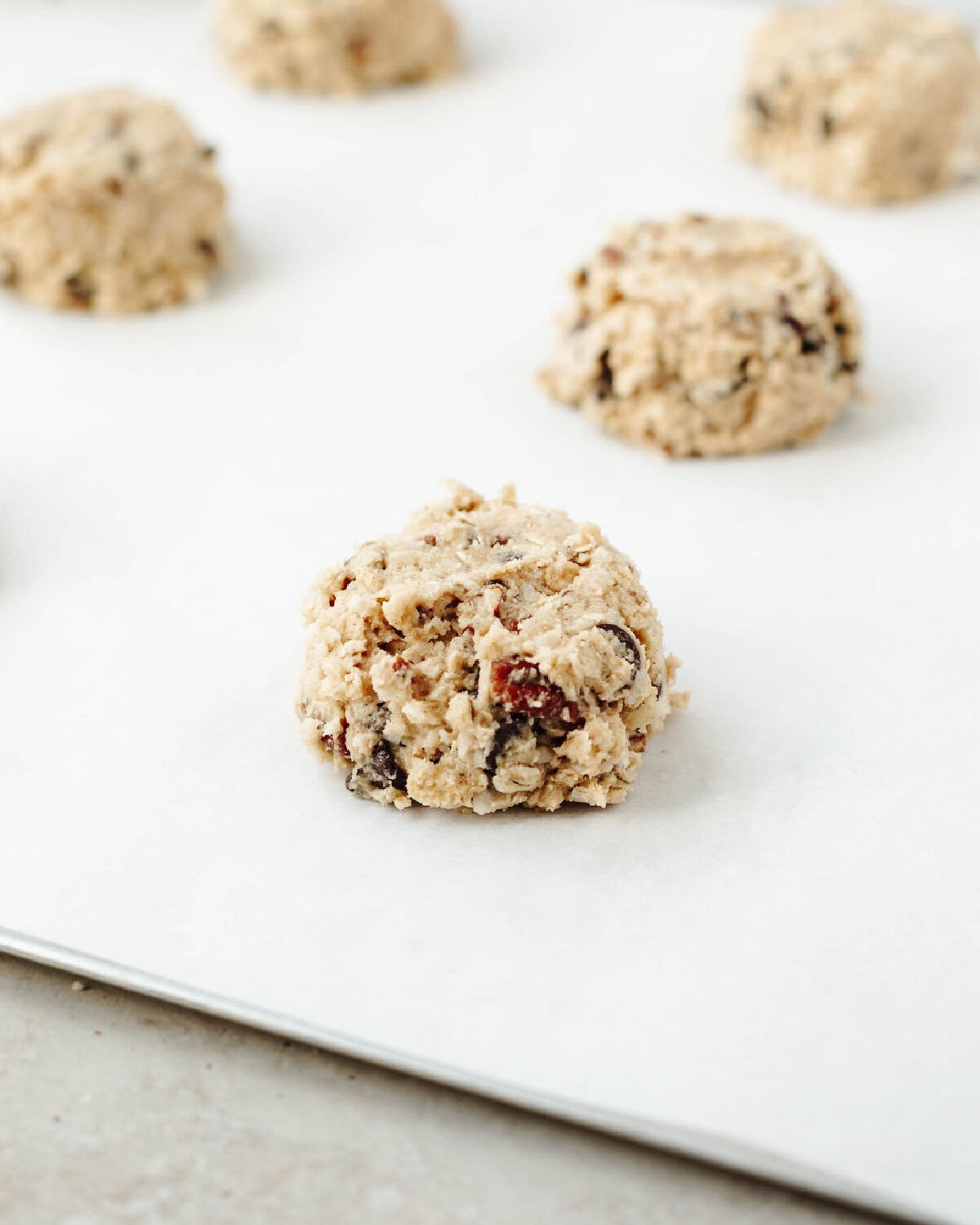 Cowboy cookie dough balls placed on a parchment lined baking sheet.