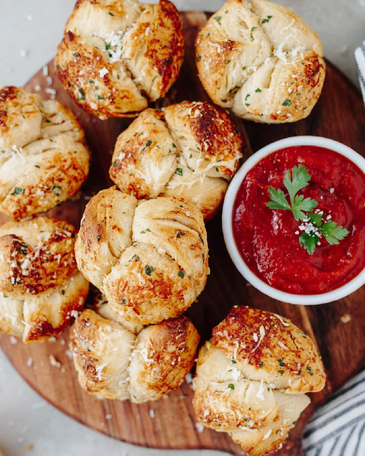 A top view of garlic monkey bread on a wood serving board.