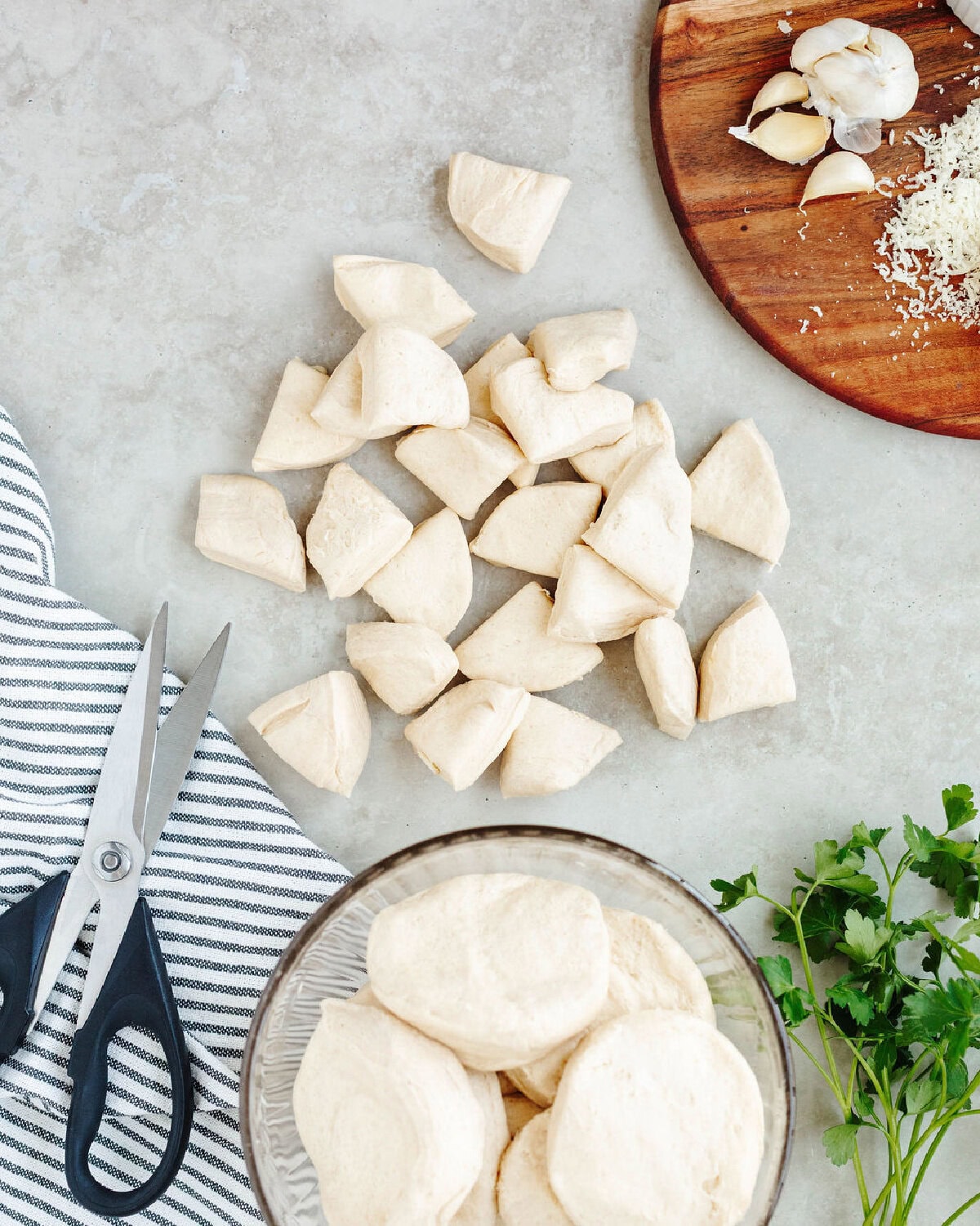 Biscuit dough being quartered using a pair of scissors.