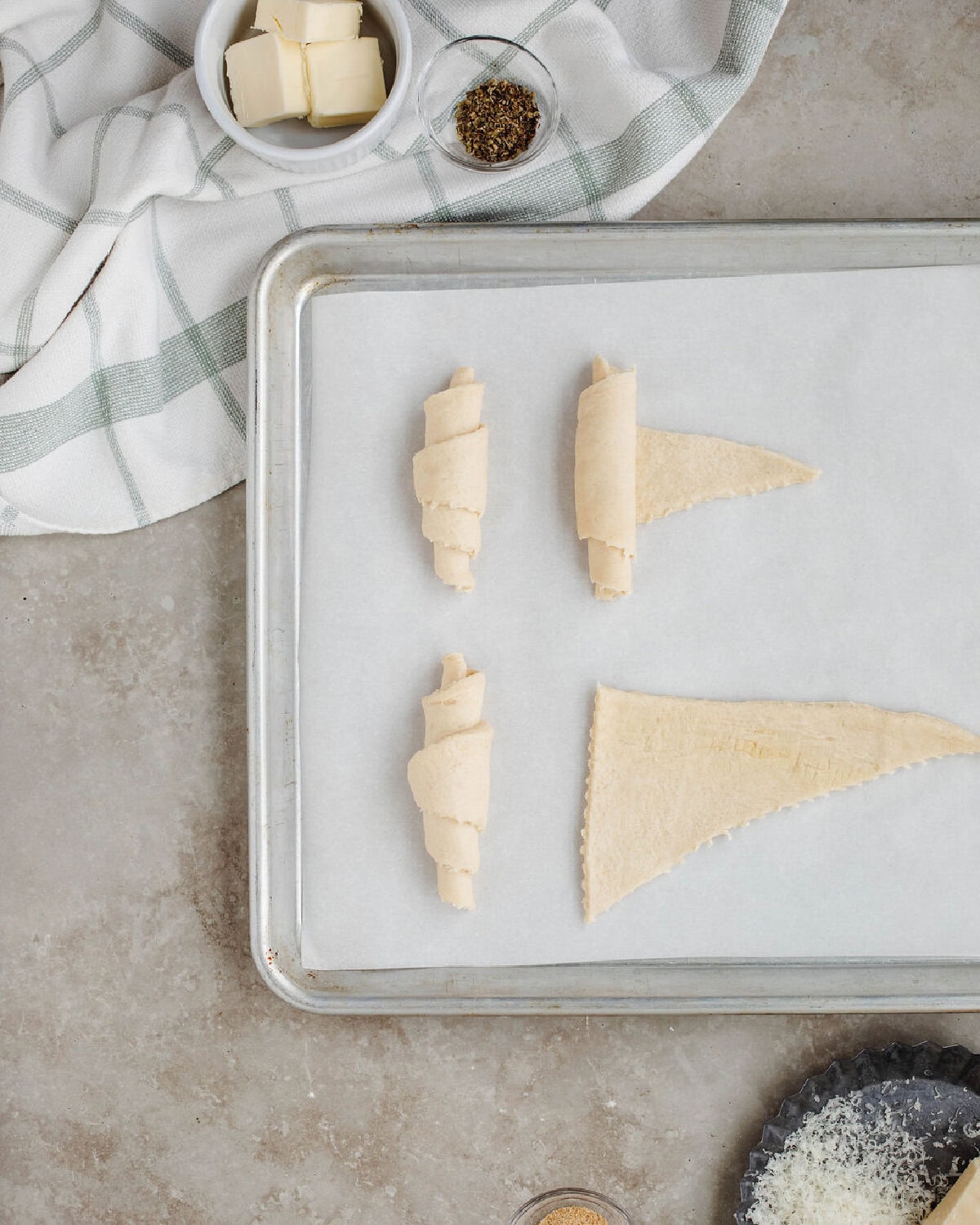 Crescent roll dough rolled and placed on a parchment lined baking sheet.