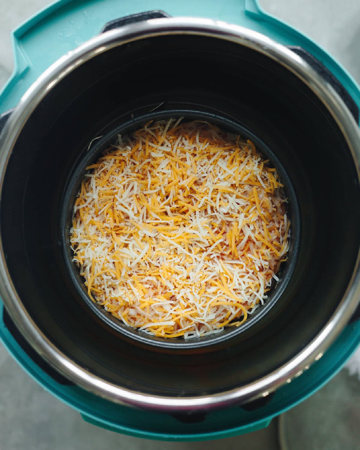 Shredded cheese sprinkled on top of instant pot enchilada casserole.