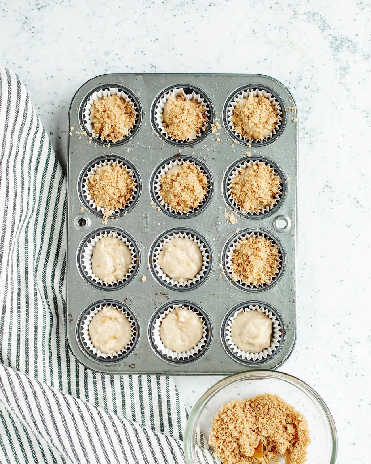 A cinnamon streusel sprinkled on top of banana muffin batter.