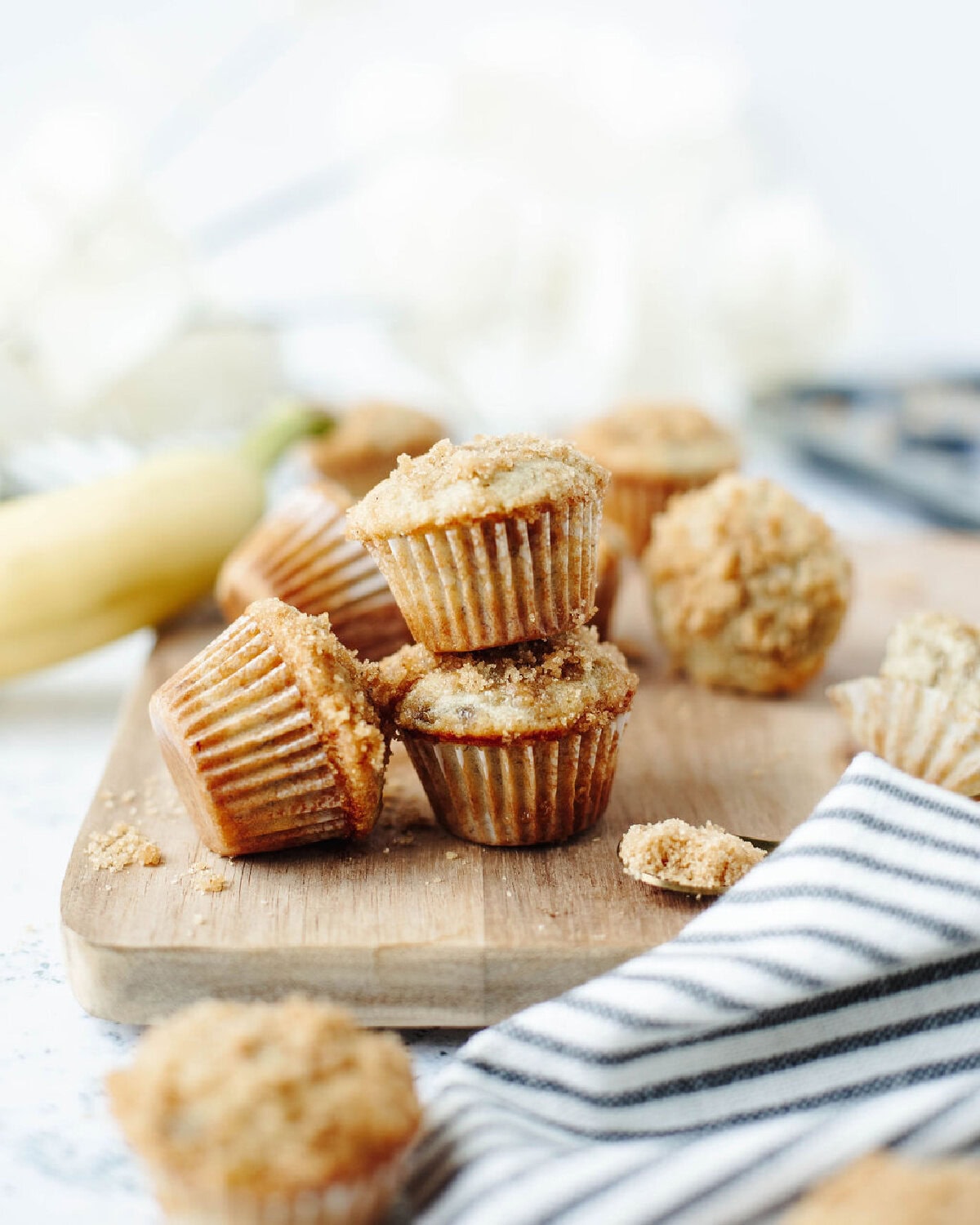 mini cinnamon banana muffins with cinnamon sugar topping on a serving board.