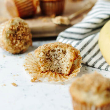 A bite taken out of a mini cinnamon banana muffin to show the inside texture.