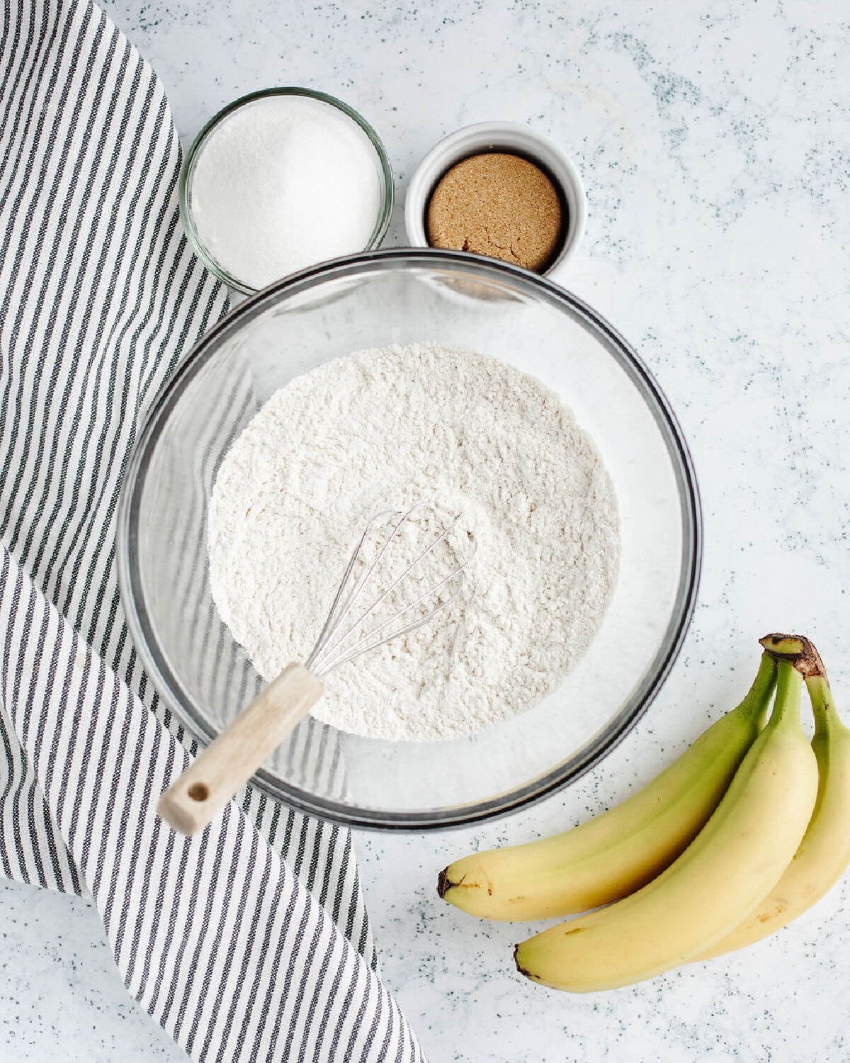 flour, baking powder, baking soda, and salt combined in a glass mixing bowl.
