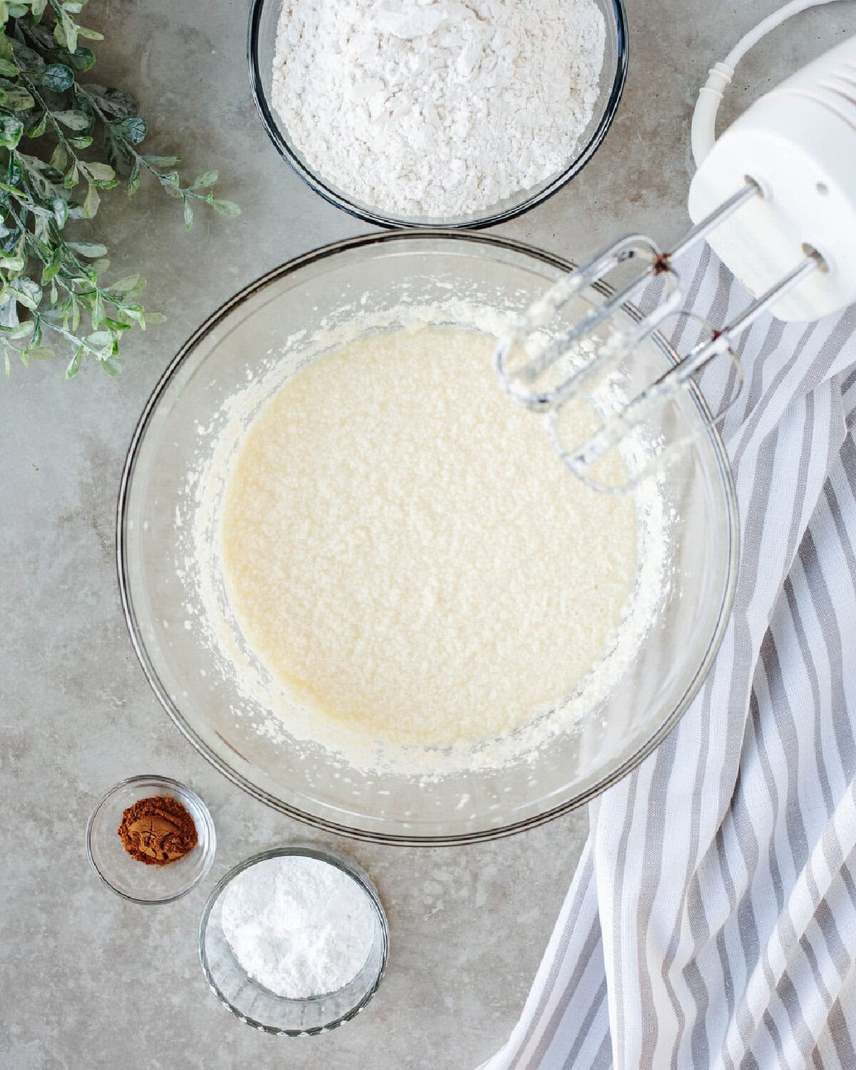 Eggs folded into creamed butter and sugar mixture in a glass mixing bowl.