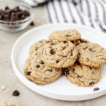 A white plate with a stack of peanut butter oatmeal chocolate chip cookies ready to serve.