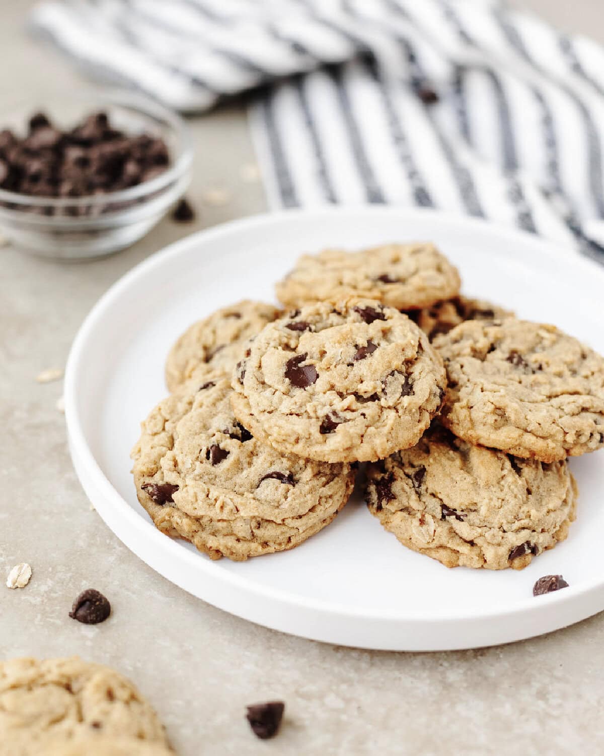 A white plate with a stack of peanut butter oatmeal chocolate chip cookies ready to serve.