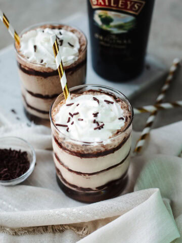 Whipped cream and chocolate sprinkles on top of two glasses of Baileys Frappuccino.