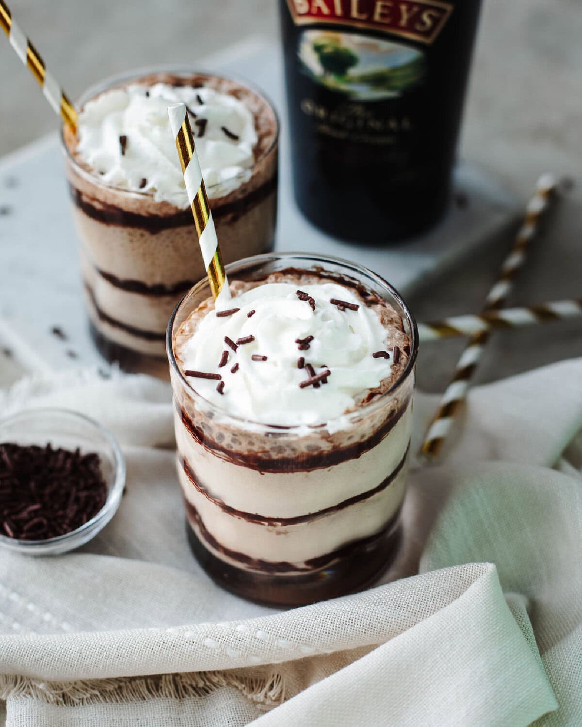 Whipped cream and chocolate sprinkles on top of two glasses of Baileys Frappuccino.