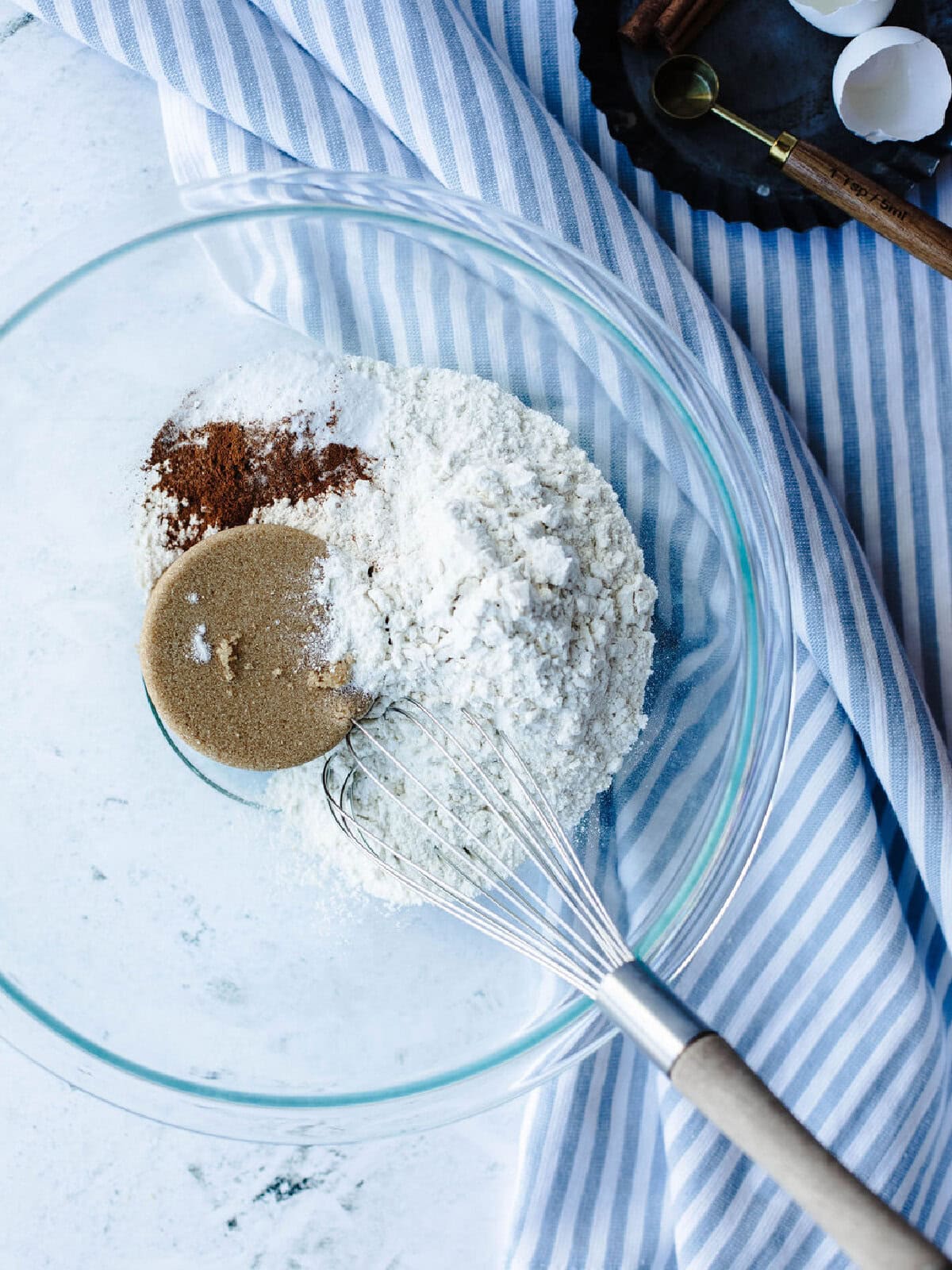 Flour, brown sugar, cinnamon, salt, baking powder, and salt whisked together in a glass mixing bowl.
