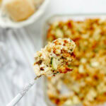 A spoon serving a scoop of chicken zucchini casserole.