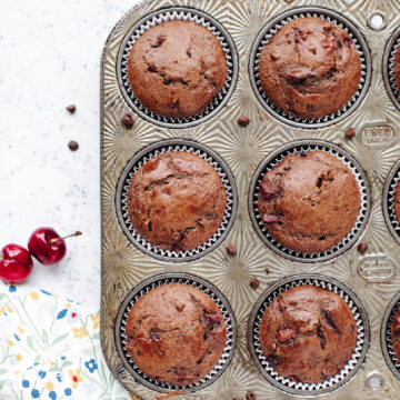 Baked chocolate cherry muffins in a muffin pan.
