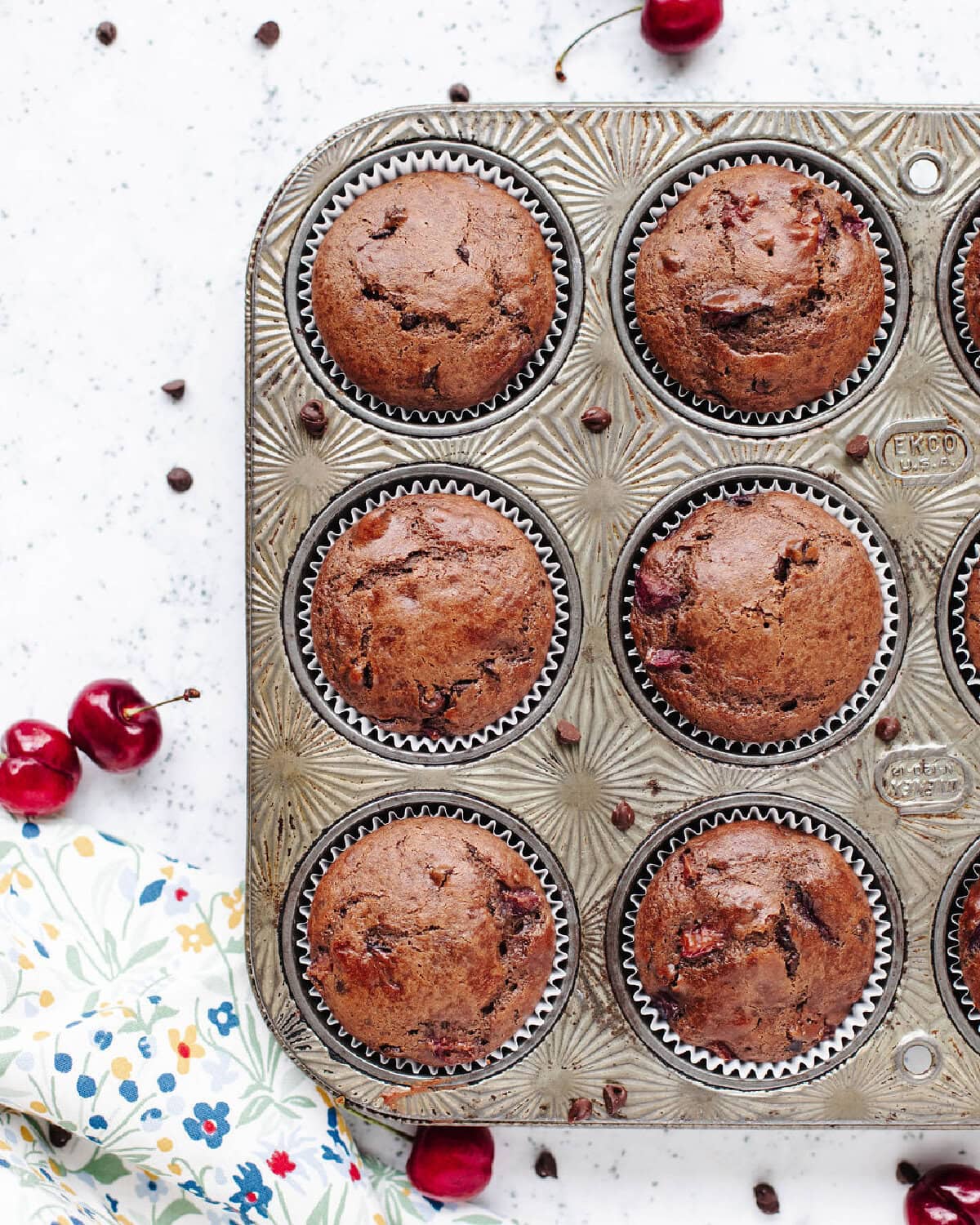 Baked chocolate cherry muffins in a muffin pan.